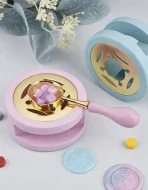 Sealing wax spoon held over candle flame melting wax beads