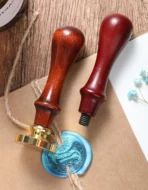Custom wax seal stamp pressed into burgundy sealing wax on envelope
